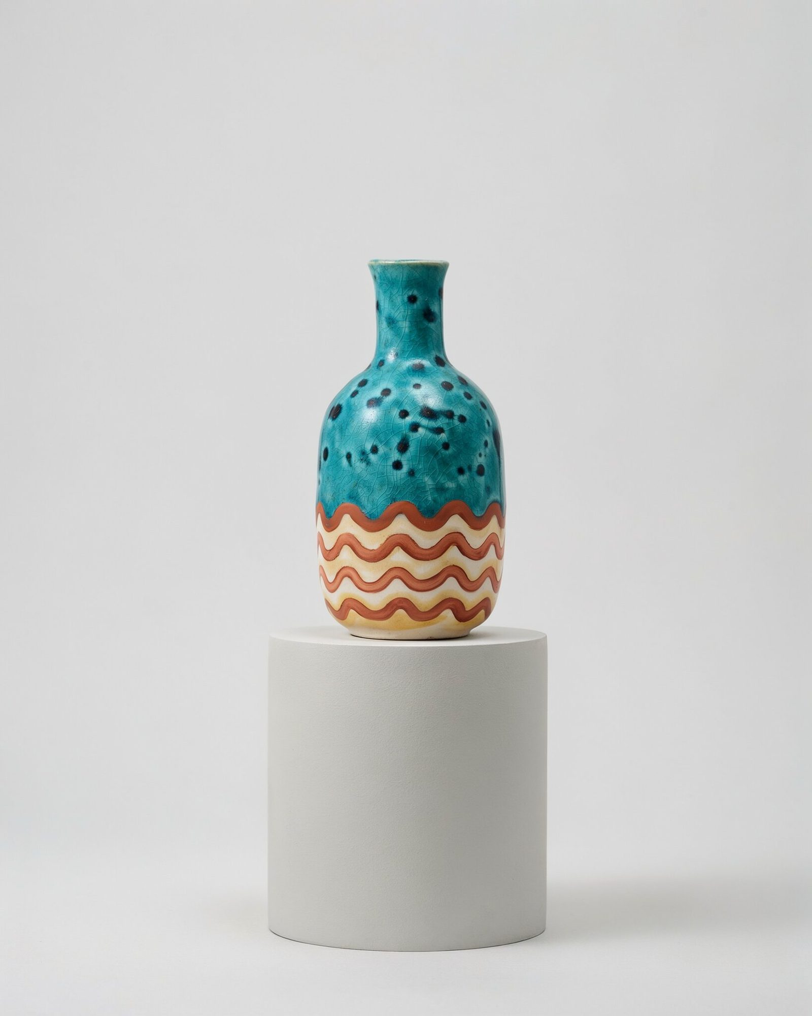 Bottle vase on a grey pedestal with a speckled teal crackle glaze on top and terracotta wave brushstrokes on cream around the lower body