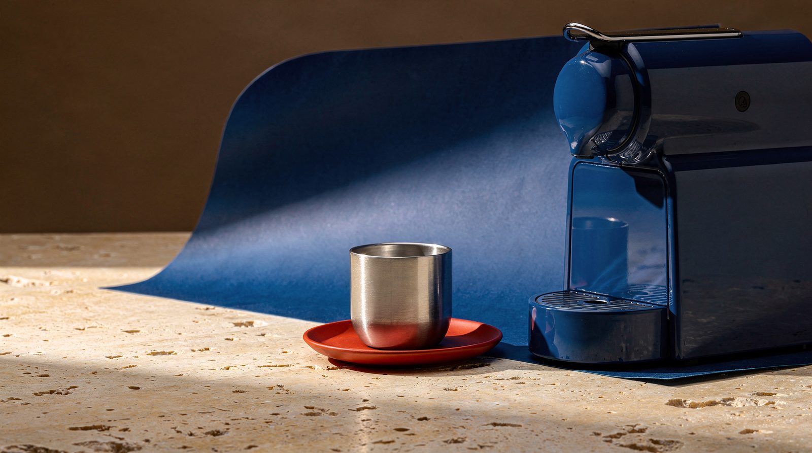 FLUX.2 Pro still life of a blue espresso machine, metal cup and orange saucer on limestone