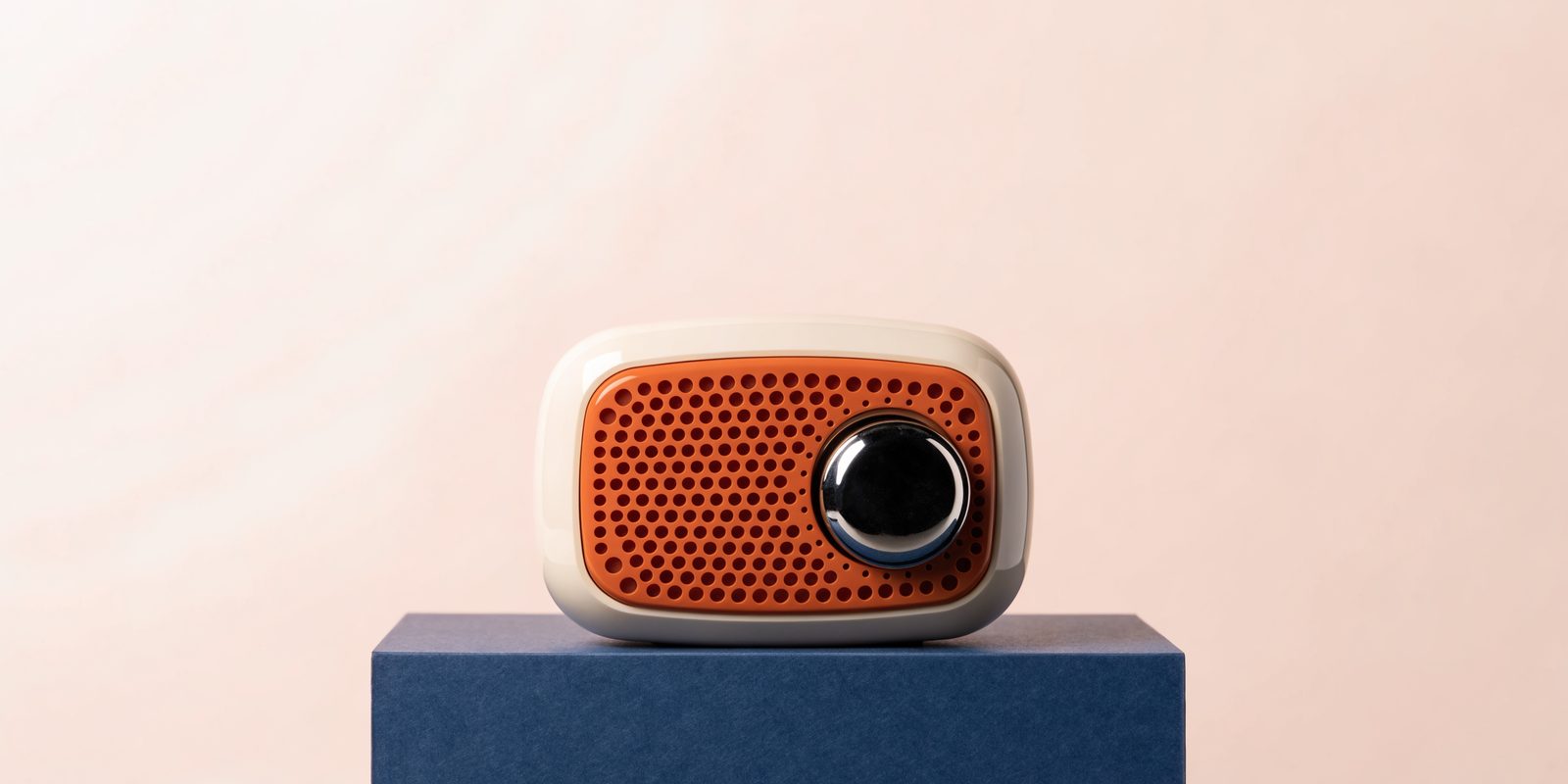 Ivory retro radio with an orange speaker grille on a navy pedestal.