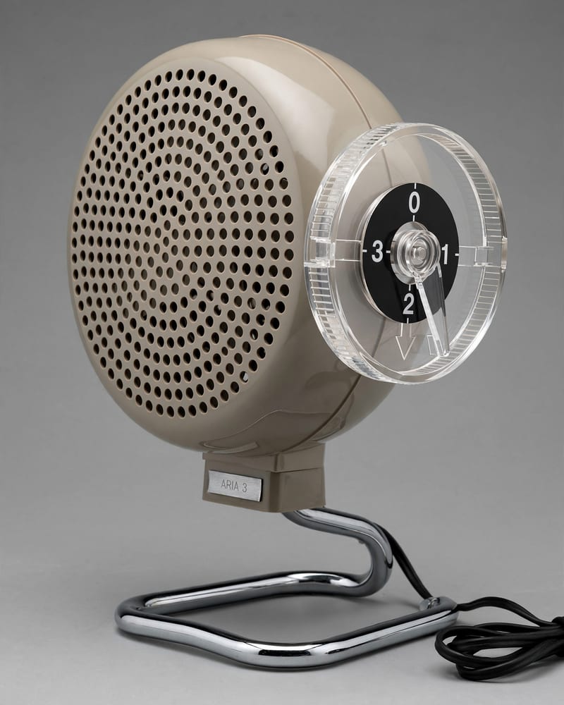 Invented late-1960s desk fan in warm grey plastic with a clear acrylic 0–3 speed wheel and an ARIA 3 nameplate on a chrome tubular stand
