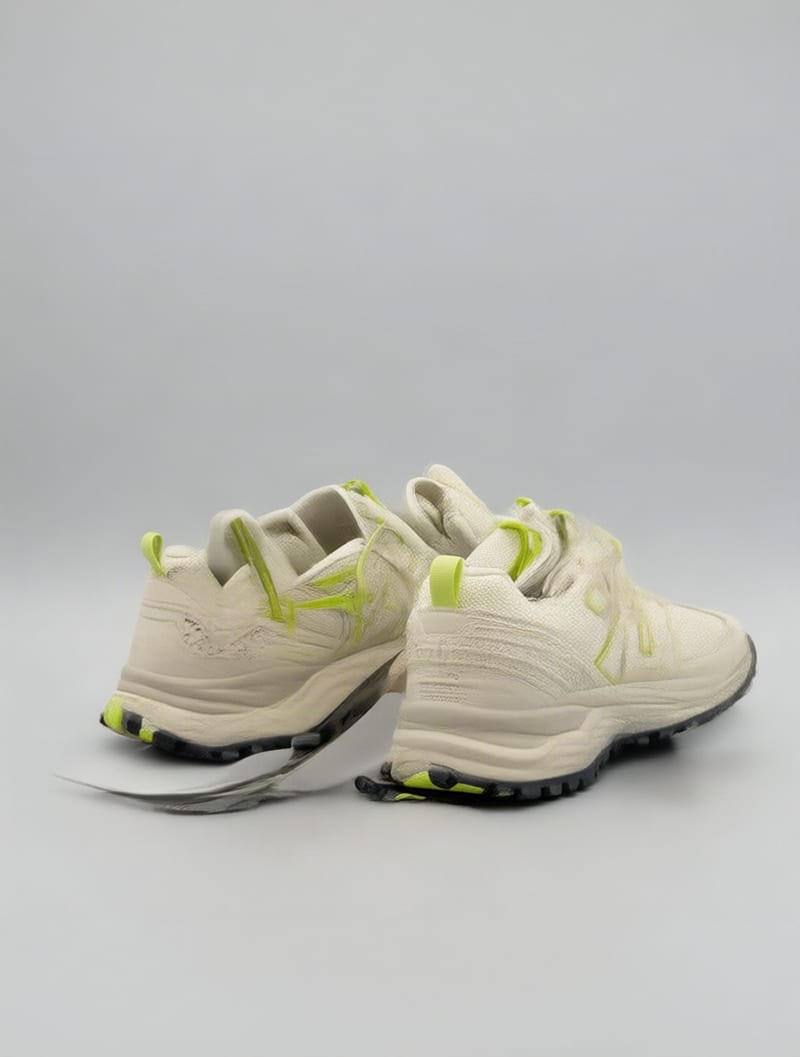 Cream and lime trail sneakers from a rear three-quarter angle, showing the lateral soles and heel tread.