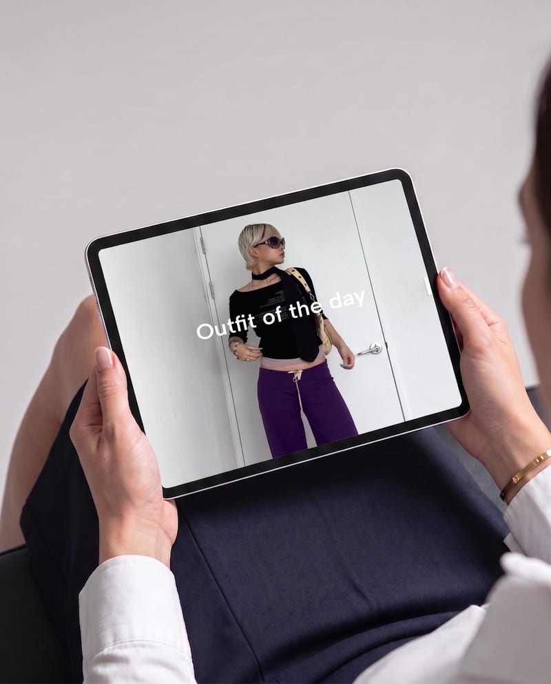 Tablet displaying a fashion social-post concept with a black top, purple trousers and an outfit-of-the-day headline.